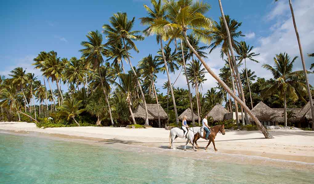 Pareja caminando por arenas blancas en Fiji COMO Laucala Island